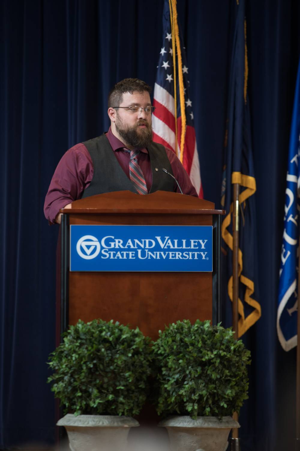 Man talking at a GVSU podium